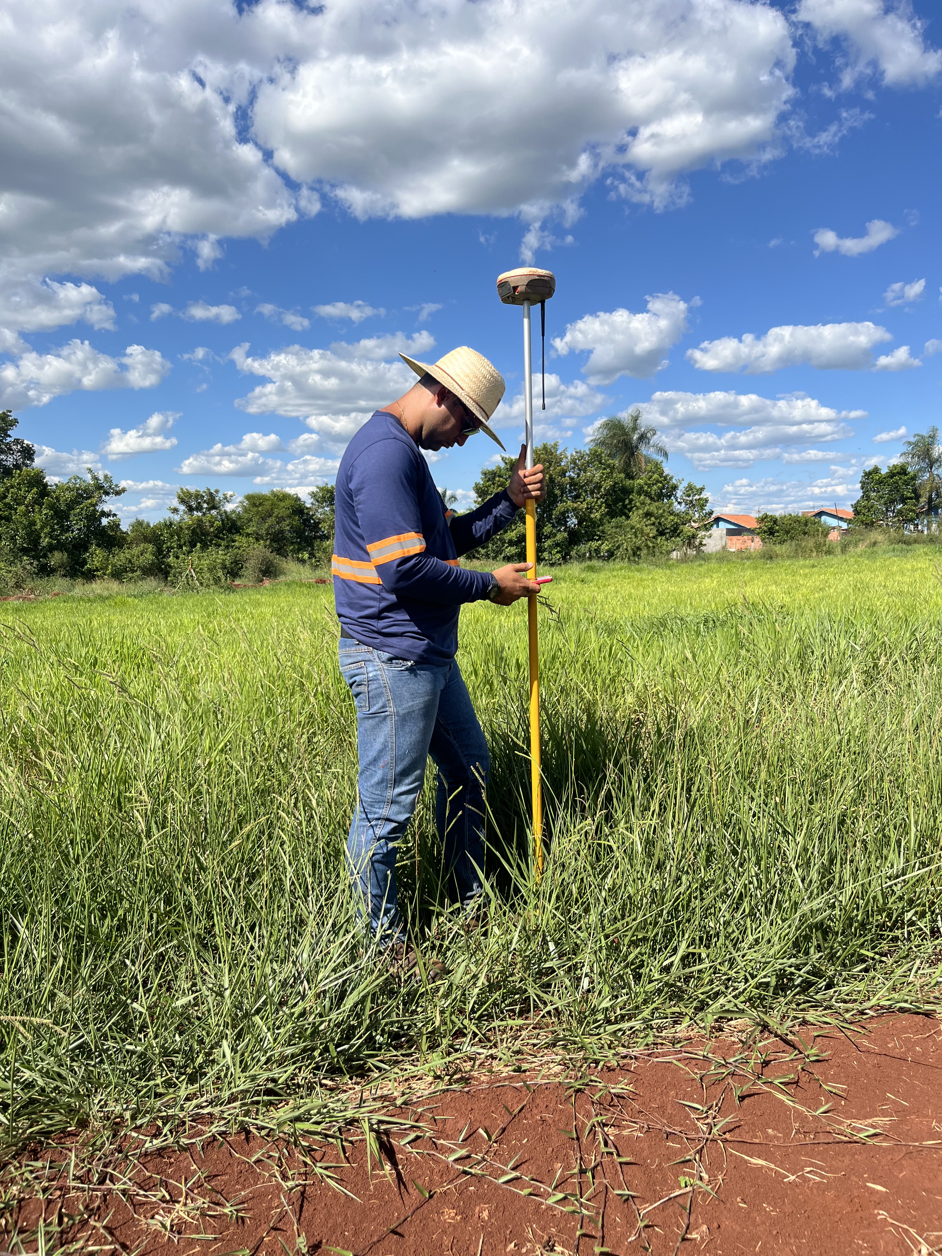 Técnico da AJ TopoGeo realizando georreferenciamento rural com receptor GNSS RTK em campo no Mato Grosso do Sul