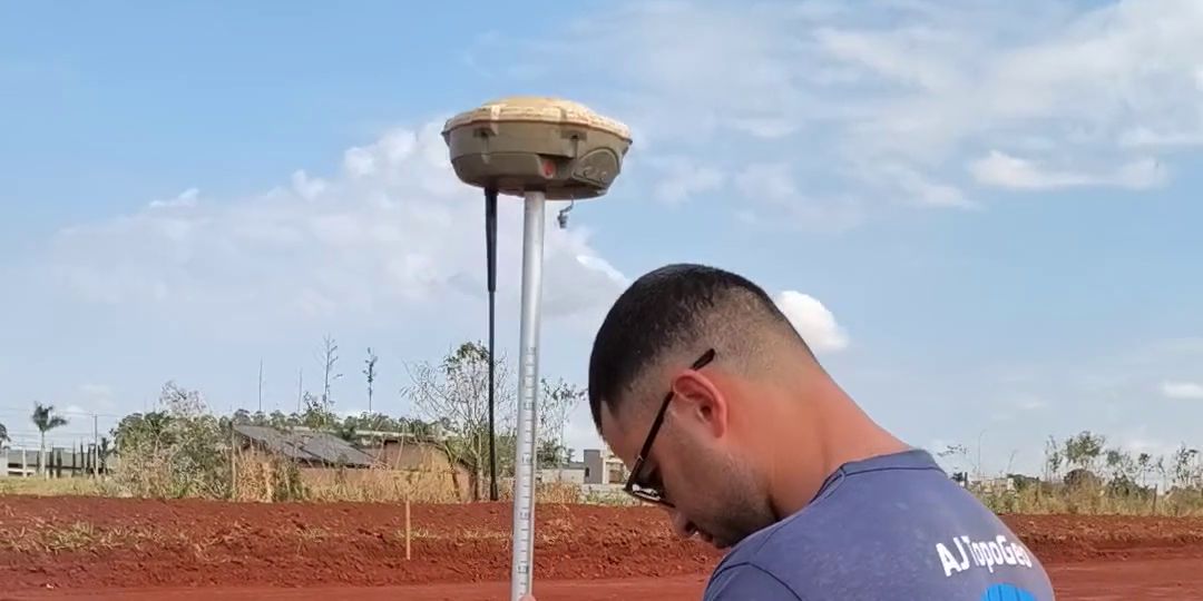 Topógrafo da AJ TopoGeo com receptor GNSS RTK locando pontos de projeto em obra de terraplanagem em Mato Grosso do Sul