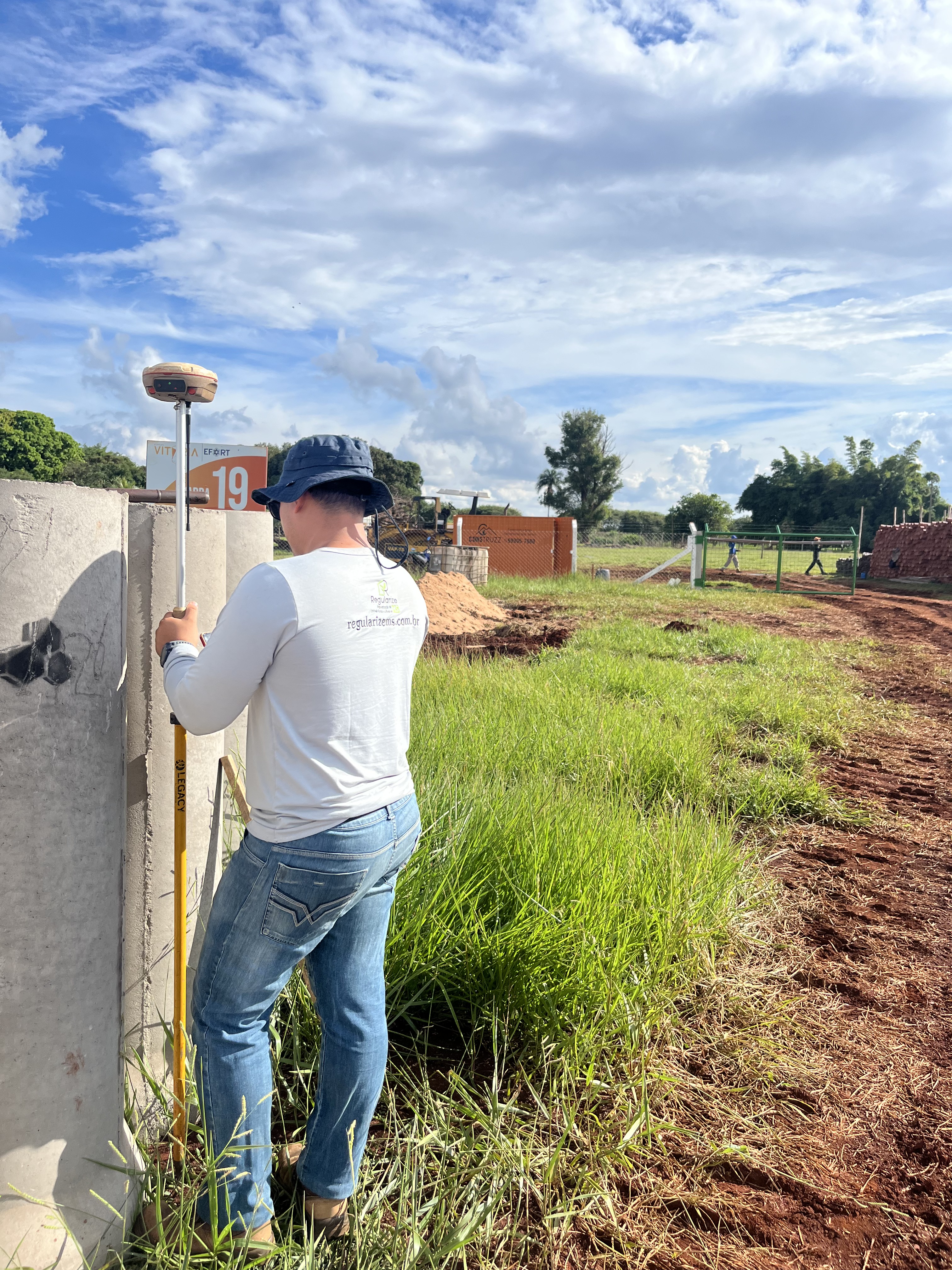 Profissional da AJ TopoGeo realizando trabalho de agrimensura com receptor GNSS RTK em divisa de terreno